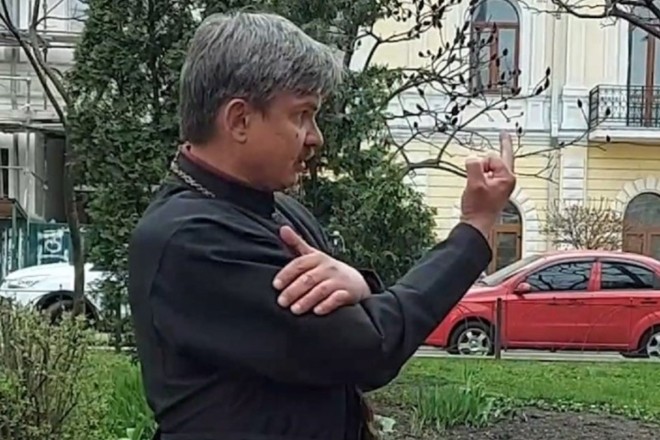 священник показує середній палець
